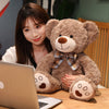 Maedchen mit dem hellbraunen Teddybaer vor dem Laptop